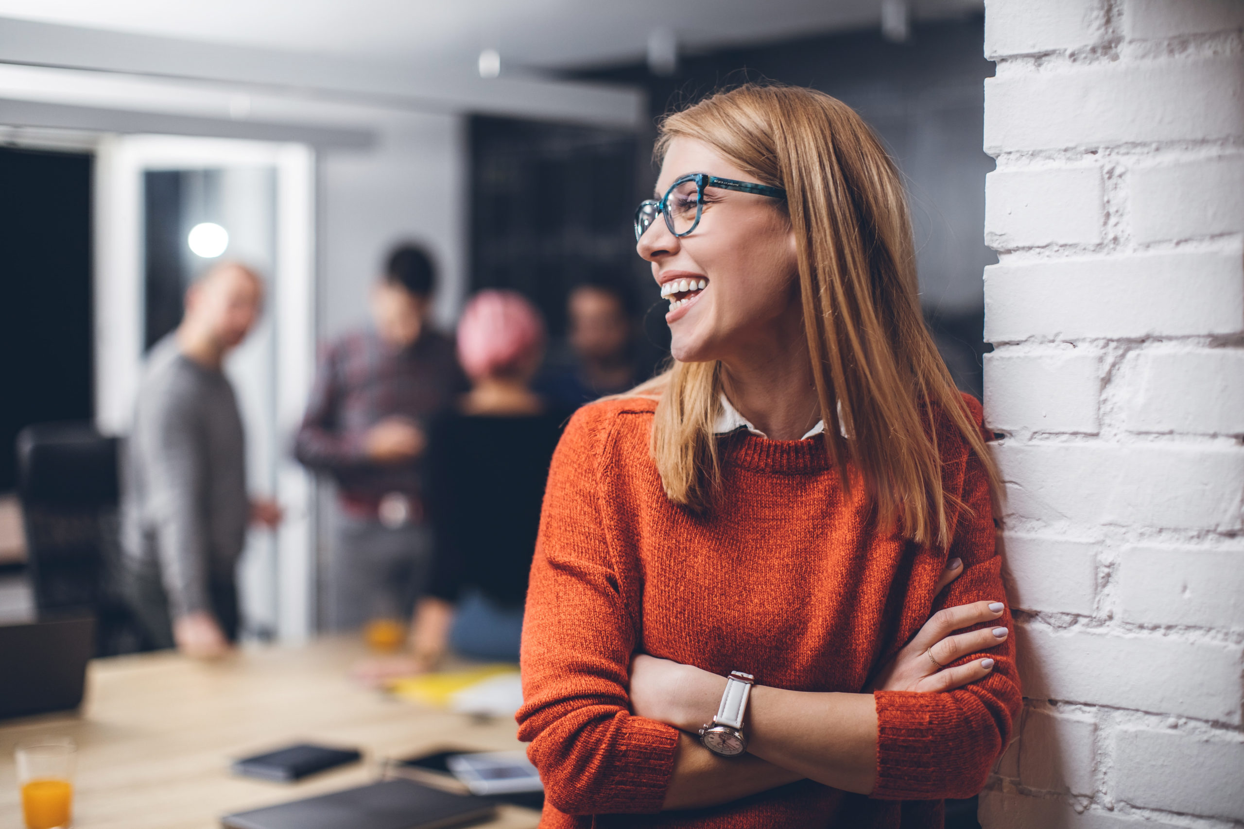 Woman laughing with her arms folded.