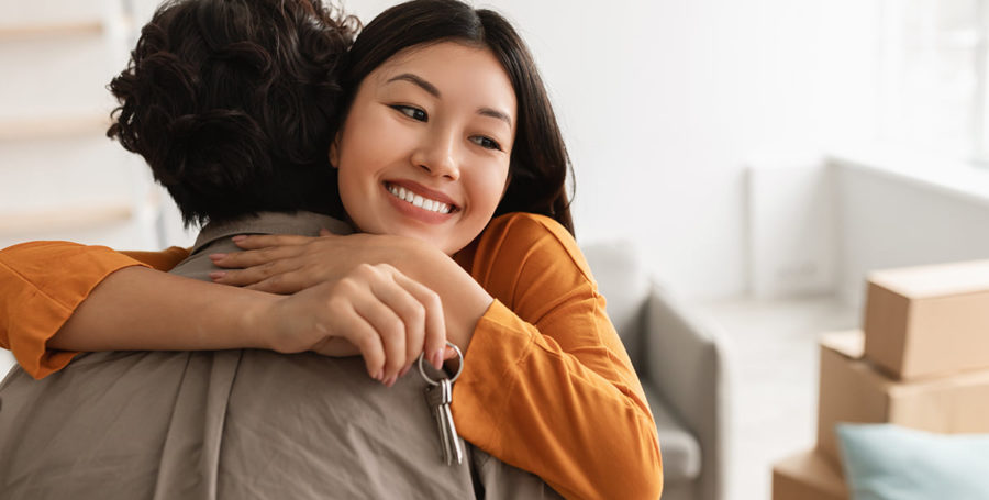 2 people hugging and smiling.