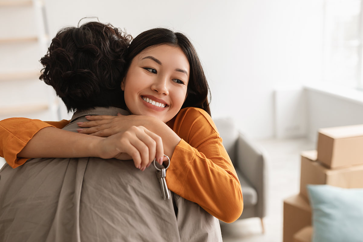 2 people hugging and smiling.